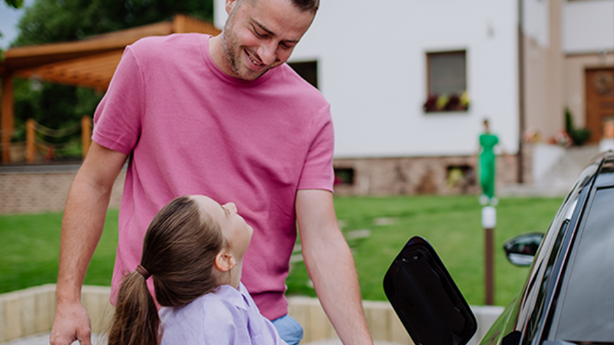 une personne branche la prise de chargement de sa voiture &eacute;lectrique